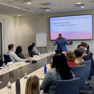 Pour Into facilitator addressing business leaders around a conference table during a leadership training session in Jacksonville